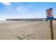 Wide shot of the beach, the ocean, the pier, and a sign that says 'Keep off the dunes' at 6000 N Ocean Blvd. # 131, North Myrtle Beach, SC 29582