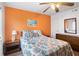 Cozy bedroom boasts an orange accent wall, comfy queen bed, and beachy artwork at 6000 N Ocean Blvd. # 131, North Myrtle Beach, SC 29582
