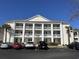 Attractive building with white pillars and ample parking on a clear, sunny day at 5020 Windsor Green Way # 103, Myrtle Beach, SC 29579