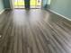 Bright living area showcasing new wood-look flooring and sliding door to an outdoor space at 5020 Windsor Green Way # 103, Myrtle Beach, SC 29579