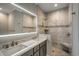 Modern bathroom features a dual-sink vanity, a lighted mirror, and a walk-in shower with marble tile at 723 10Th Ave. S, Surfside Beach, SC 29575