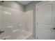 This bathroom features a shower and tub combination with white walls and door at 723 10Th Ave. S, Surfside Beach, SC 29575