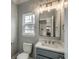 Well-lit bathroom featuring a toilet, a sink vanity, and a large mirror at 723 10Th Ave. S, Surfside Beach, SC 29575