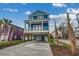 Charming blue two-story home with a covered porch, spacious driveway, and lush landscaping at 723 10Th Ave. S, Surfside Beach, SC 29575