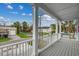 View from a covered porch showing wood decking, white pillars and railings and a view of the street at 723 10Th Ave. S, Surfside Beach, SC 29575
