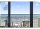 Balcony view of Myrtle Beach oceanfront with white plastic chairs and a table at 1105 S Ocean Blvd. # 904, Myrtle Beach, SC 29577