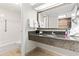 A clean bathroom with a vanity featuring a granite countertop, a well-lit mirror, and a view of the kitchen at 1105 S Ocean Blvd. # 904, Myrtle Beach, SC 29577