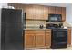 This kitchen is equipped with black appliances, wood cabinetry, granite countertops, and tile flooring, offering functionality and style at 1105 S Ocean Blvd. # 904, Myrtle Beach, SC 29577