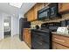 Efficient kitchen design with black appliances, wooden cabinets, and tiled flooring, providing a practical cooking space at 1105 S Ocean Blvd. # 904, Myrtle Beach, SC 29577