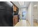 Compact kitchen featuring black appliances, wooden cabinets and tile flooring leading to a view of the ocean from the doorway at 1105 S Ocean Blvd. # 904, Myrtle Beach, SC 29577