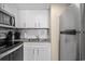 Kitchen with stainless steel appliances, white cabinets, and a double basin sink at 6804 N Ocean Blvd. # 1037, Myrtle Beach, SC 29572