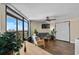 Bright living room featuring tile floors, a ceiling fan, sliding glass doors leading to a balcony, and partial ocean views at 6804 N Ocean Blvd. # 1037, Myrtle Beach, SC 29572
