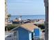 Scenic ocean view with a blue building, parked cars, and palm trees at 9621 Shore Dr. # J-229, Myrtle Beach, SC 29572