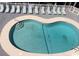 Outdoor Kidney shaped pool surrounded by pool furniture, and with a metal ladder at 9621 Shore Dr. # J-229, Myrtle Beach, SC 29572