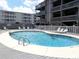 Inviting complex pool area featuring a swimming pool with people enjoying the water on a sunny day at 9621 Shore Dr. # J-229, Myrtle Beach, SC 29572