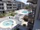 Aerial view of a pool area with a hot tub and lush landscaping surrounded by condo buildings at 9621 Shore Dr. # J-229, Myrtle Beach, SC 29572