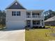 Charming two-story home featuring a covered porch, a two-car garage, and professional landscaping at 121 Fair Meadow Ct., Loris, SC 29569