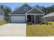 Charming single-story home showcasing a manicured lawn, neutral siding, and an attached two-car garage at 125 Fair Meadow Ct., Loris, SC 29569
