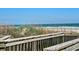 Scenic view of the ocean from a wooden beach access with sandy dunes and vegetation at 9820 Queensway Blvd. # 501, Myrtle Beach, SC 29572