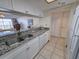 Well-lit kitchen with stone countertops, stainless steel sink, and white cabinetry providing a functional cooking space at 9820 Queensway Blvd. # 501, Myrtle Beach, SC 29572