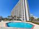 Exterior angle showing a building with a pool and sundeck area, surrounded by palm trees at 9820 Queensway Blvd. # 501, Myrtle Beach, SC 29572