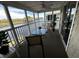 Relaxing screened balcony with water view, ceiling fan, seating, and sliding glass door entry at 220 Landing Rd. # I, North Myrtle Beach, SC 29582