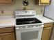 White electric range with white countertops and wood cabinets at 220 Landing Rd. # I, North Myrtle Beach, SC 29582