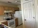 Clean kitchen featuring white appliances, wood cabinets, and adjacent door at 220 Landing Rd. # I, North Myrtle Beach, SC 29582