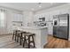 Modern kitchen with an island, stainless steel appliances, white cabinets, and hardwood floors at 3035 Deerberry Place, Longs, SC 29568