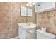 Compact bathroom offers a vanity with storage, toilet, and decorative wallpaper at 4733 Wild Iris Dr. # 302, Myrtle Beach, SC 29577