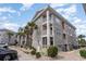 Charming condo building with stone facade, multiple balconies, and beautiful landscaping for relaxed living at 4733 Wild Iris Dr. # 302, Myrtle Beach, SC 29577