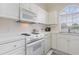 Functional kitchen featuring white appliances, ample counter space, and an arched window with natural light at 4733 Wild Iris Dr. # 302, Myrtle Beach, SC 29577