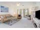 Bright living room with comfortable seating, a ceiling fan, and a large window offering natural light at 4733 Wild Iris Dr. # 302, Myrtle Beach, SC 29577