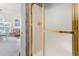Bathroom shower with glass doors and gold hardware with adjacent living area at 4733 Wild Iris Dr. # 302, Myrtle Beach, SC 29577