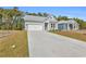 View of single-story home with gray siding, a well-manicured lawn, and a long concrete driveway at 397 Sun Colony Blvd., Longs, SC 29568