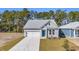 An eye-level side view of a charming single-story home with gray siding and a blue door at 397 Sun Colony Blvd., Longs, SC 29568