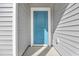 A close-up view of a vibrant blue front door with sidelight, complemented by gray siding and white trim at 397 Sun Colony Blvd., Longs, SC 29568