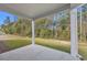 Covered patio with white pillars offering a view of the private, wooded backyard at 397 Sun Colony Blvd., Longs, SC 29568