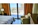 Bedroom showcasing a comfortable armchair, side table, and balcony access with a view of the outdoors at 9550 Shore Dr. # 925, Myrtle Beach, SC 29572