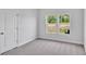Bedroom with neutral carpet, two windows, and a white door at 439 Waterend Dr. # 8, Little River, SC 29566