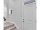 Bright entryway featuring a white front door, small window, and carpeted stairs at 233 Sandridgebury Dr. # 57, Little River, SC 29566