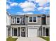 A charming two-story townhome with gray siding, white trim, and an attached garage at 233 Sandridgebury Dr. # 57, Little River, SC 29566