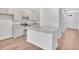 Bright, open kitchen with granite countertops, stainless appliances, and light wood floors at 233 Sandridgebury Dr. # 57, Little River, SC 29566