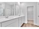 Bathroom with double sink vanity, framed mirrors, and walk-in closet at 293 Sandridgebury Dr. # 66, Little River, SC 29566