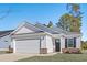 Newly built home with white siding, brick accents, and a two-car garage at 734 Woodside Dr., Conway, SC 29526