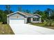 Gray siding one story house with white garage door and landscaping at 4516 East Coast Ln., Shallotte, NC 28470