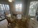 Dining area features glass table with rattan chairs and a view of the screened-in porch at 1500 Cenith Dr. # F103, North Myrtle Beach, SC 29582