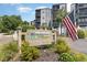 Exterior shows community signage with an American flag and well-maintained landscaping around the sign at 1500 Cenith Dr. # F103, North Myrtle Beach, SC 29582