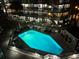 Night shot shows the bright-blue community swimming pool with multiple chairs for lounging around it at 1500 Cenith Dr. # F103, North Myrtle Beach, SC 29582