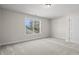 Bedroom with a window allowing for natural light, plush carpet, and a door for access at 623 Carter Reid Ct., Longs, SC 29568